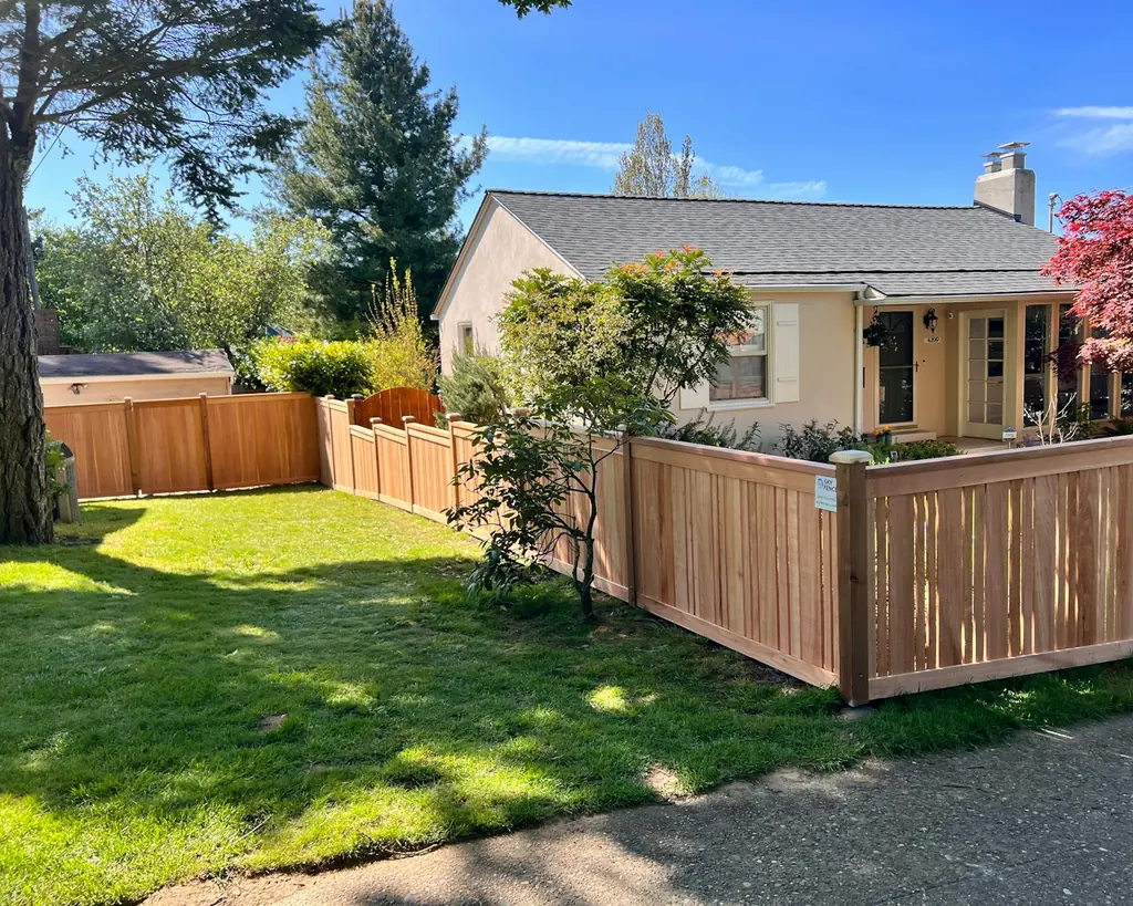 A house with a new wood fence around the front yard